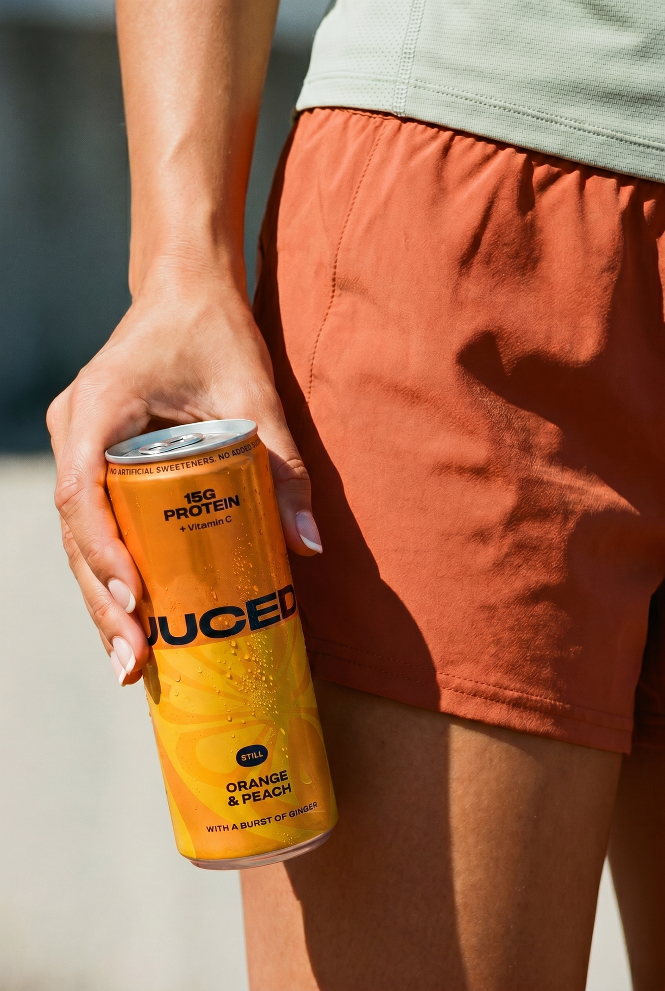 A can of JUCED collagen protein drink being held by a woman, representing clean protein from hydrolysed bovine collagen