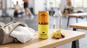 A can of JUCED Pineapple & Passionfruit protein drink beside a gym bag, water bottle and fresh pineapple on a bench, representing an easy protein routine for gym beginners