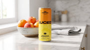 A can of JUCED Pineapple & Passionfruit protein drink on a bright kitchen counter beside a bowl of fresh fruit, representing a light, low calorie way to add protein and satiety to a balanced diet