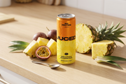 A can of JUCED clean label protein drink on a kitchen counter beside fresh fruit and a short, simple ingredient list, representing a genuinely clean label protein drink