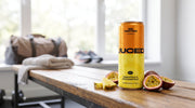 Can of JUCED protein drink resting on a gym bench next to a kit bag and water bottle, protein before or after a workout
