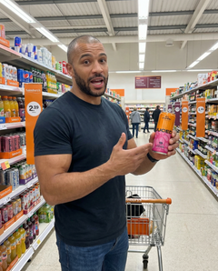 A person holding a can of JUCED collagen protein drink in a supermarket, talking about the comparison between collagen protein vs whey