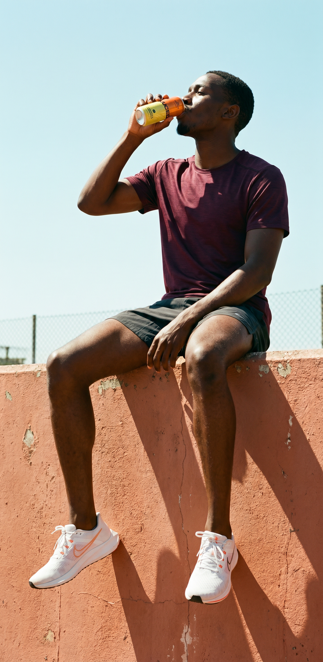 A man drinking a can of refreshing JUCED in the sunshine