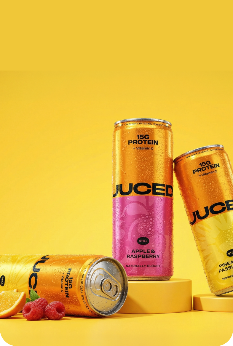 Three cans of JUCED protein drinks on a yellow background
